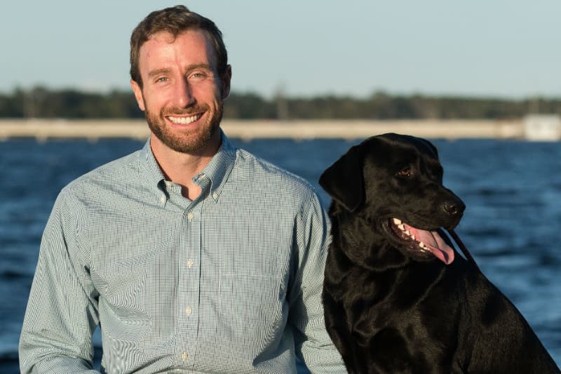 Dr MacKenzie with Nugget in front of a lake