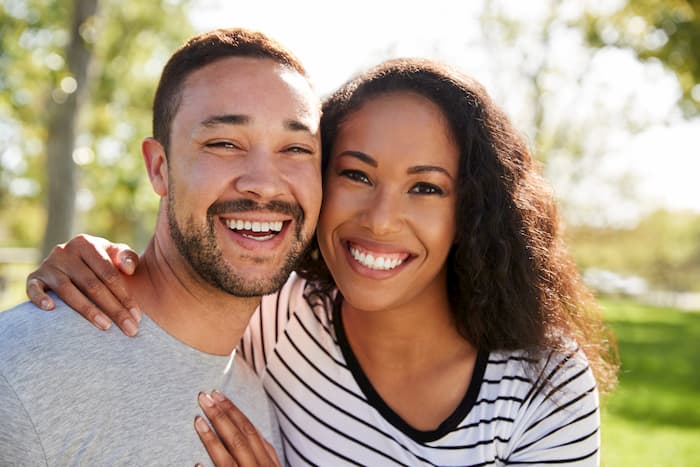 Woman and man smiling together showing off their beautiful smiles.