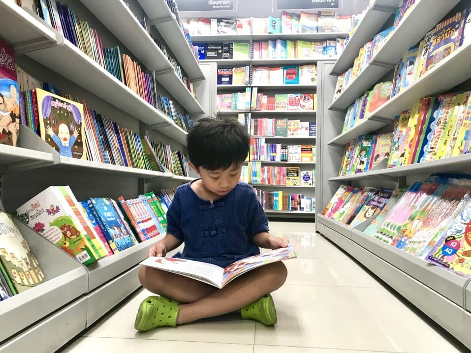 Little boy sitting reading a book about the dentist.