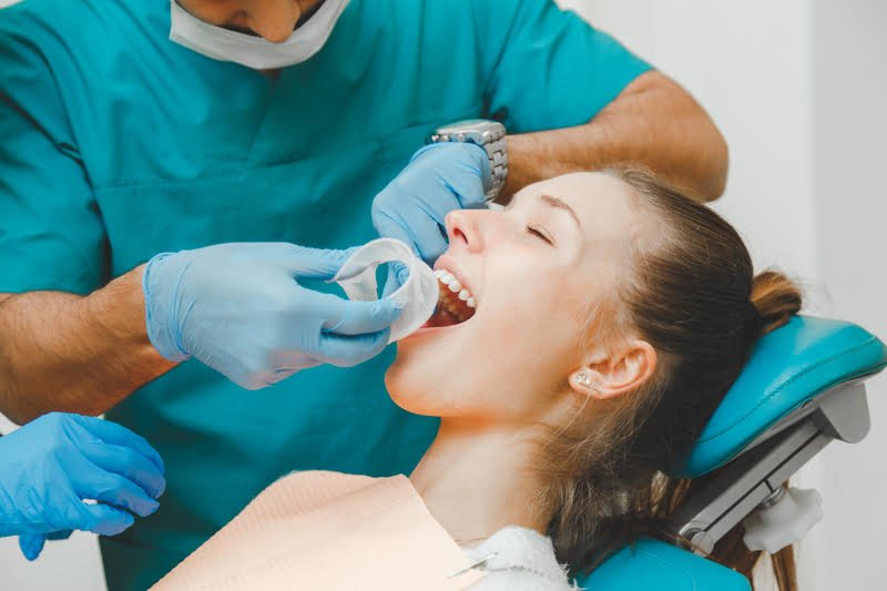 A woman getting her teeth checked by a dentist