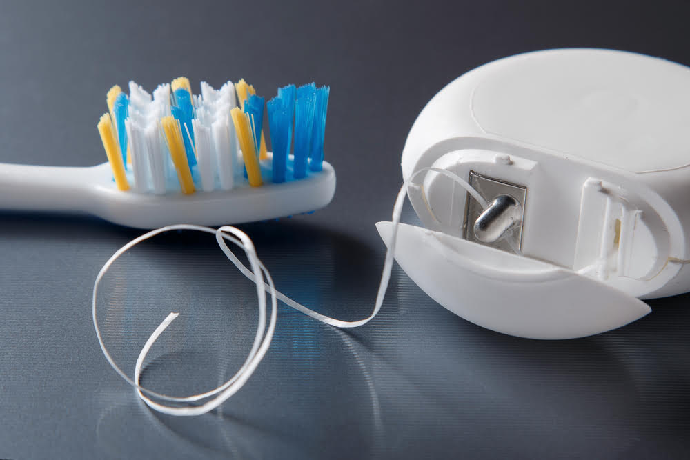 Electric toothbrush and toothpaste dispenser on a table for maintaining gum health