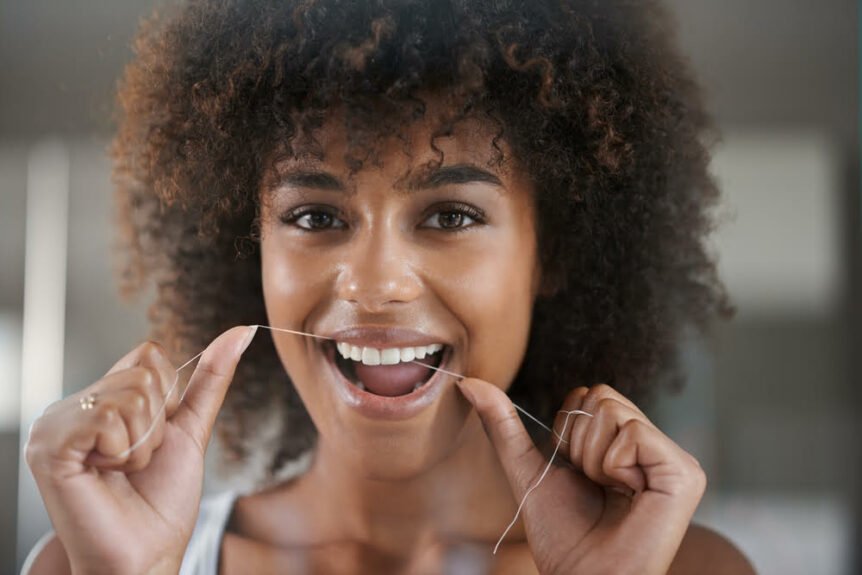A woman demonstrating proper flossing technique